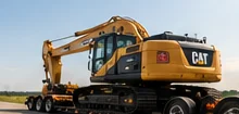 Low-deck trailer transporting heavy equipment